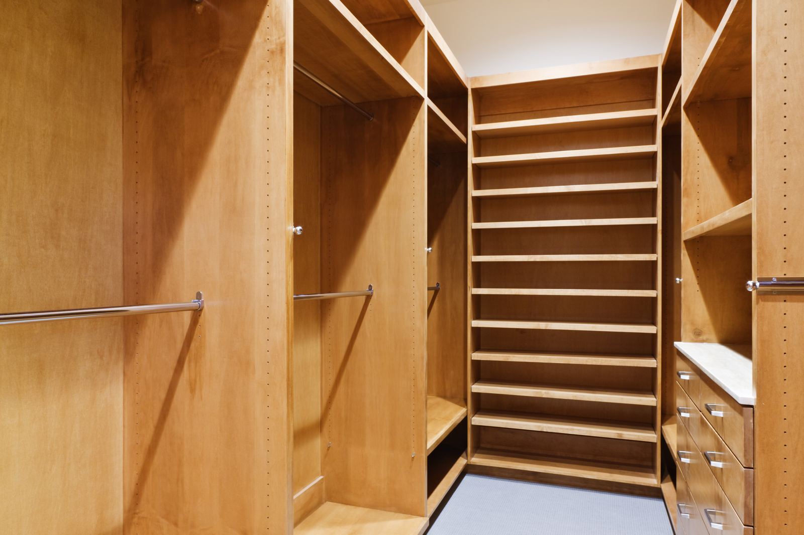 Walk-in closet with shoe shelving and drawer bank